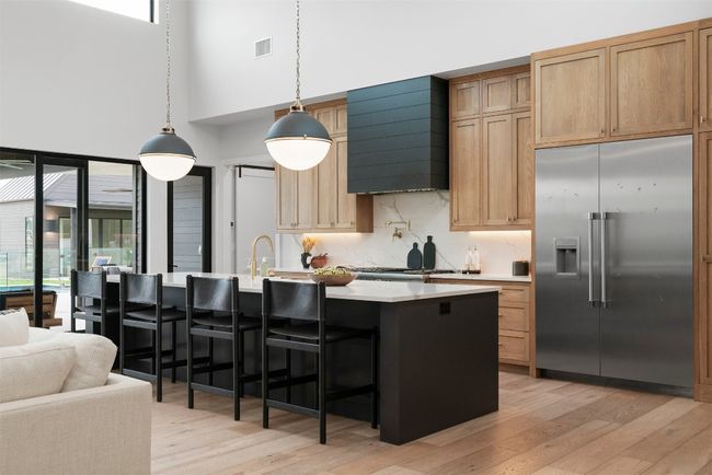 The oversized island, wrapped in exquisite quartz, provides ample seating and workspace, making it the heartbeat of the home | Image 11