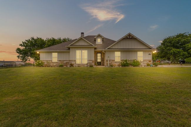 View of front of property featuring a chimney, stone siding, and a shingled roof | Image 27