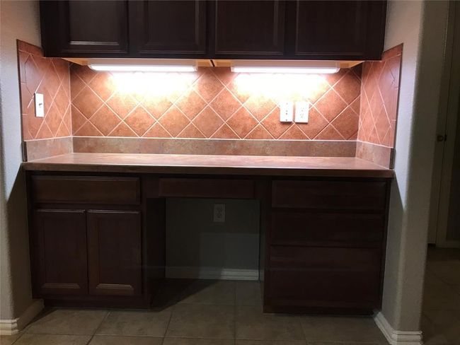 Kitchen with light tile patterned floors, baseboards, tasteful backsplash, and light countertops | Image 9