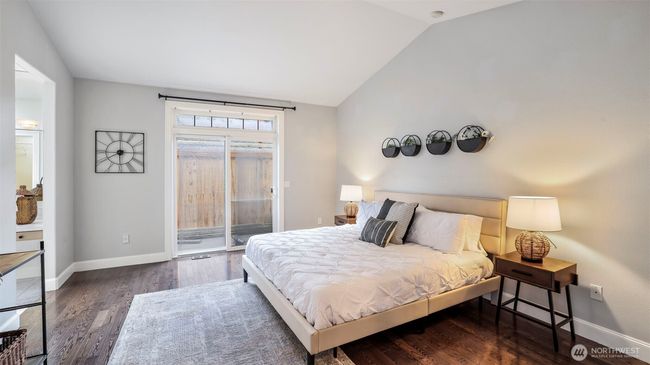 Enjoy a bright and airy primary bedroom on the main floor, complete with a sliding door to the backyard and direct access to a private en suite bathroom | Image 9