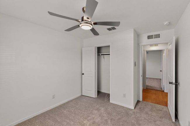 Unfurnished bedroom featuring carpet, baseboards, a closet, and ceiling fan | Image 24