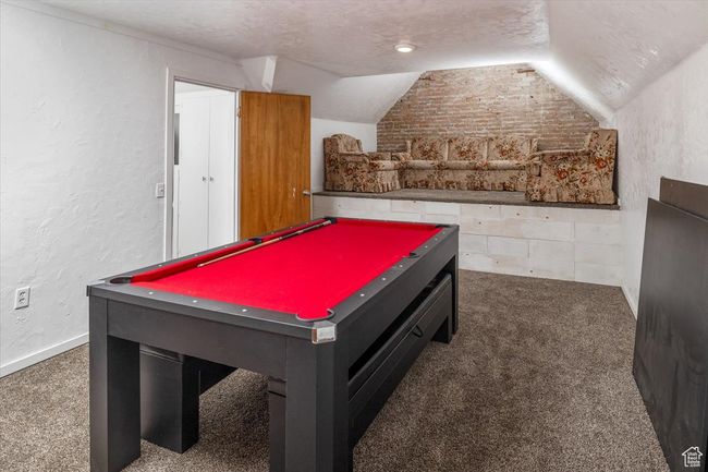 Recreation room with dark carpet, a textured ceiling, pool table, and lofted ceiling | Image 24