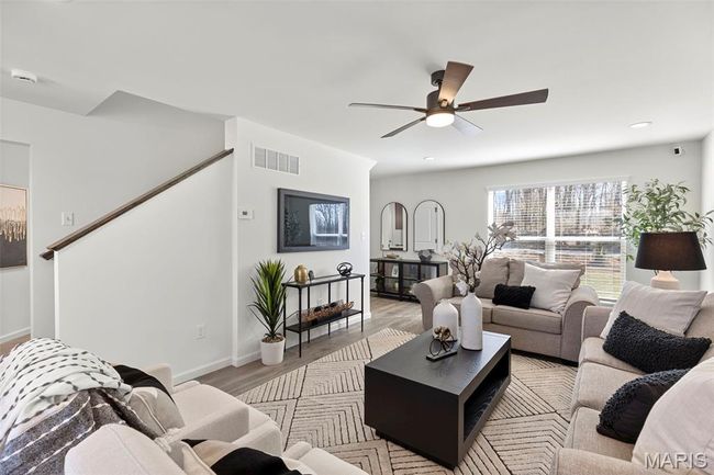 Living room featuring ceiling fan, light wood-style flooring, baseboards, stairs, and recessed lighting | Image 4