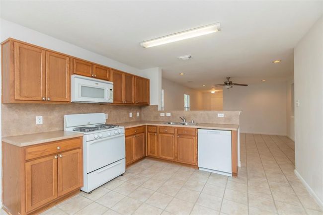 Open Kitchen. Functional kitchen with ample cabinet space with white appliances. | Image 8