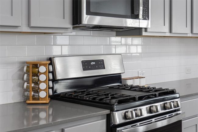 Kitchen with stainless steel appliances, stainless steel counters, and backsplash | Image 13