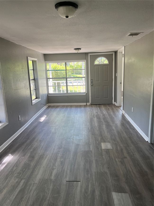 Entrance foyer featuring a textured ceiling, baseboards, visible vents, and dark wood finished floors | Image 4