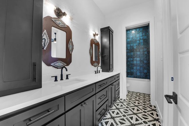 Full bath featuring tile patterned flooring, double vanity, toilet, and a sink | Image 11