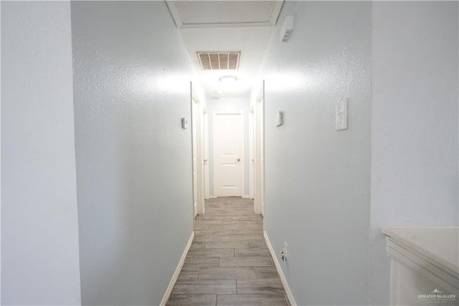 Hall featuring light wood-type flooring and attic access | Image 5