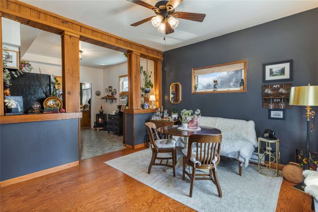 Dining space featuring wood finished floors, ceiling fan, and a wood stove | Image 9