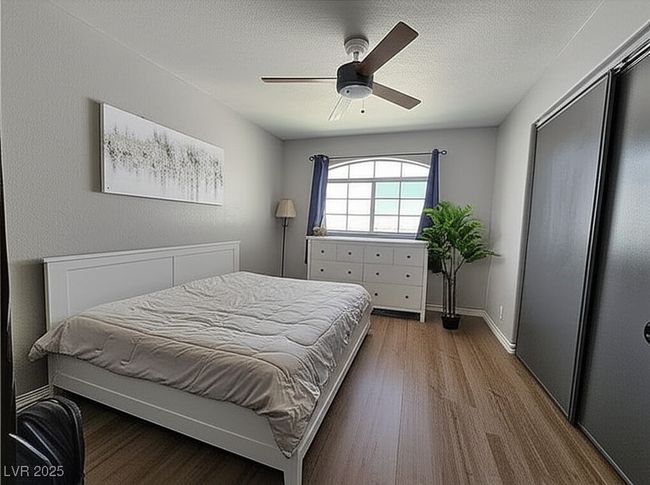 Bedroom with wood finished floors, a closet, a textured ceiling, and a ceiling fan | Image 19