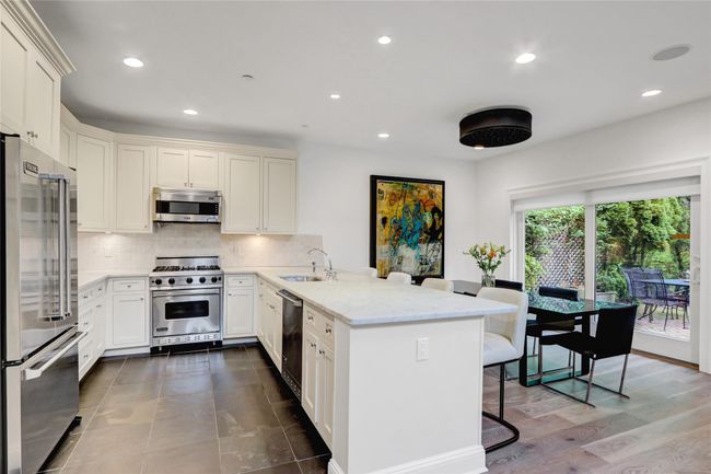 Kitchen featuring premium appliances, a sink, a breakfast bar, and tasteful backsplash | Image 8