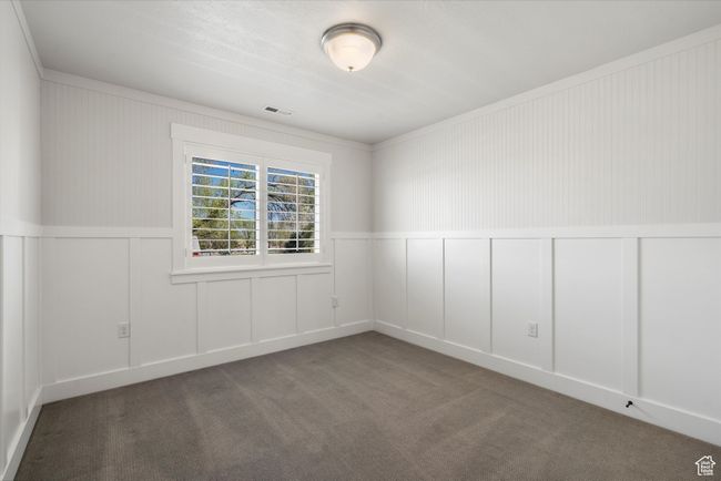 Unfurnished room featuring a decorative wall, visible vents, and carpet floors | Image 40