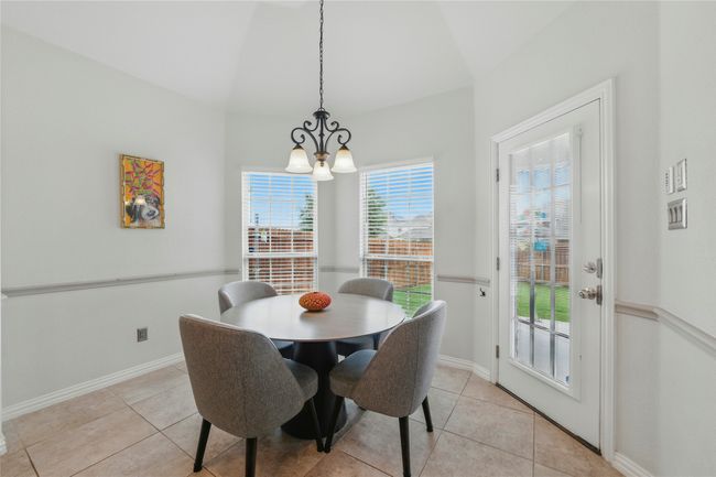 Dining room featuring a chandelier, light tile patterned flooring, and lofted ceiling | Image 15
