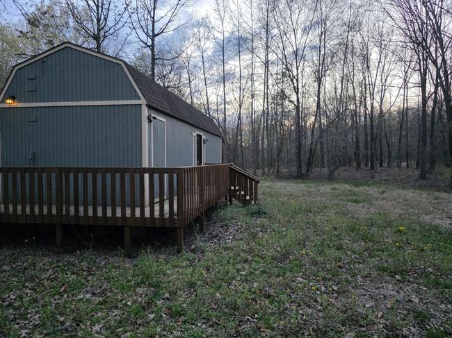 View of home's exterior featuring a gambrel roof and a deck | Image 5