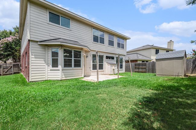 This photo shows the well-maintained backyard. It features a patio area and a storage shed. The yard is fenced, providing privacy and a secure space for outdoor activities. | Image 17