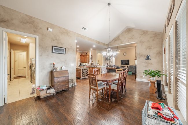 Dining space featuring vaulted ceiling, a chandelier, and dark wood finished floors | Image 15