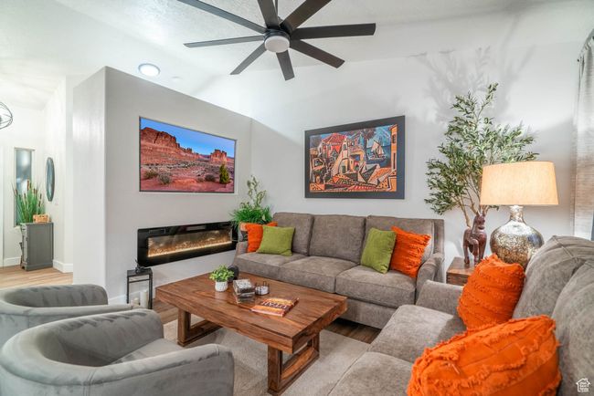 Living room featuring ceiling fan, a textured ceiling, and light wood-type flooring | Image 5