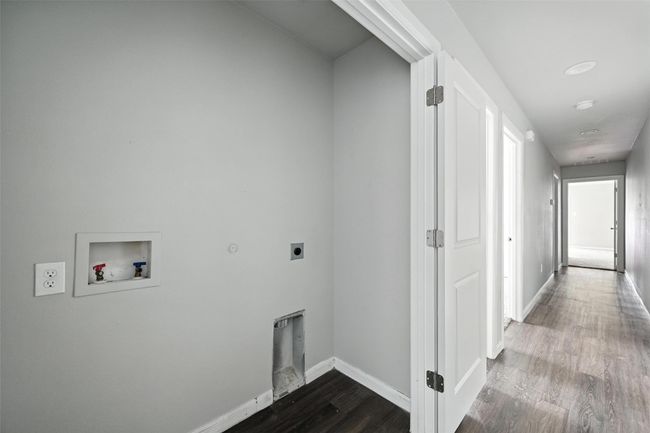 Laundry room with dark wood-style flooring, hookup for a washing machine, electric dryer hookup, and hookup for a gas dryer | Image 15