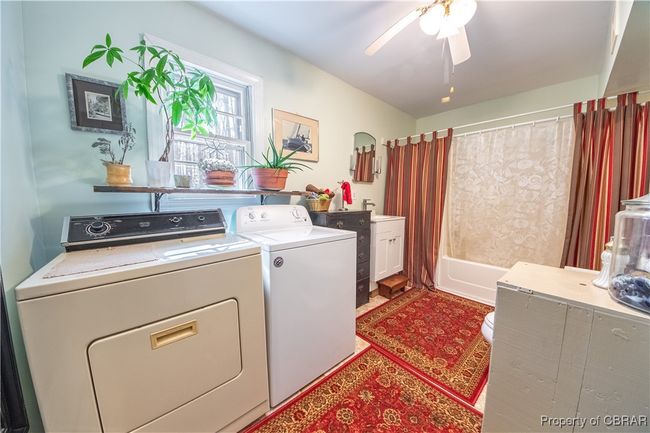 Clothes washing area featuring washing machine and clothes dryer, laundry area, and a ceiling fan | Image 12