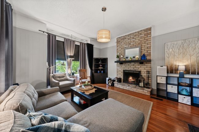 Living room featuring wood finished floors and a brick fireplace | Image 9