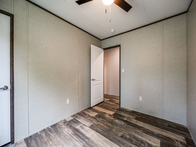 Unfurnished bedroom with a ceiling fan, ornamental molding, and dark wood finished floors | Image 14