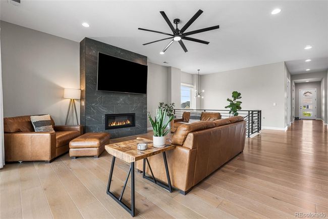 Floor to ceiling tiled fireplace, upgraded ceiling fan, white oak engineered hardwood floors - 12' sliding glass doors to outdoor patio/dining area | Image 11