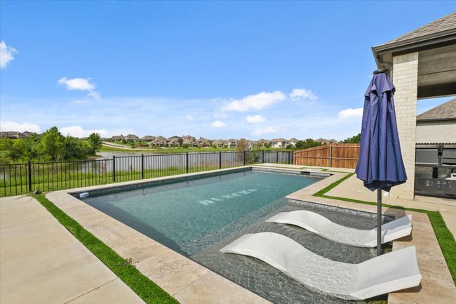 View of swimming pool featuring a fenced backyard, a water view, a residential view, and a patio area | Image 28