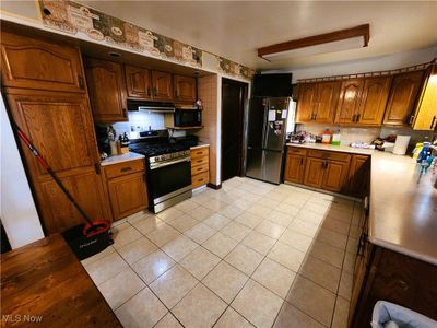 Kitchen featuring appliances with stainless steel finishes, backsplash, and light tile patterned floors | Image 3