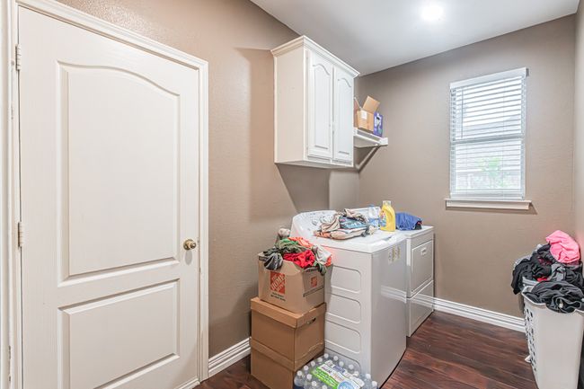 Washroom with washing machine and clothes dryer, dark wood-style floors, and cabinet space | Image 33