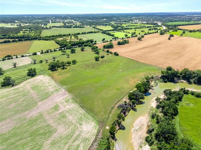 Aerial view of sparsely populated area featuring a large body of water | Image 7