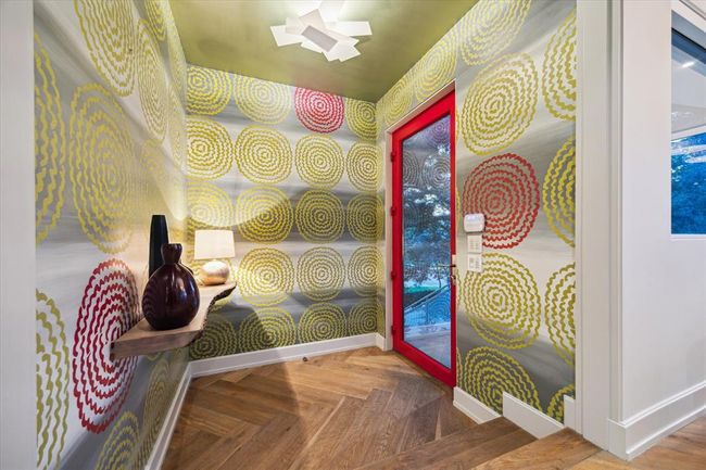The entry sets the tone for the entire home. A custom-commissioned, hand-painted wallpaper creates an unforgettable first impression, beautifully complemented by a striking glossy red glass door. Welcome! | Image 5