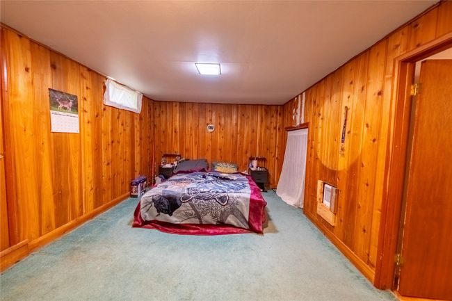 Carpeted bedroom featuring wood walls | Image 40
