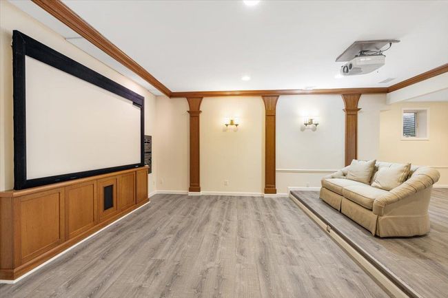 Home theater room with light wood-style flooring, crown molding, baseboards, and recessed lighting | Image 18