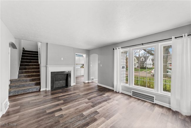 Living room featuring a decorative fireplace and large picture window with plenty of natural light | Image 6