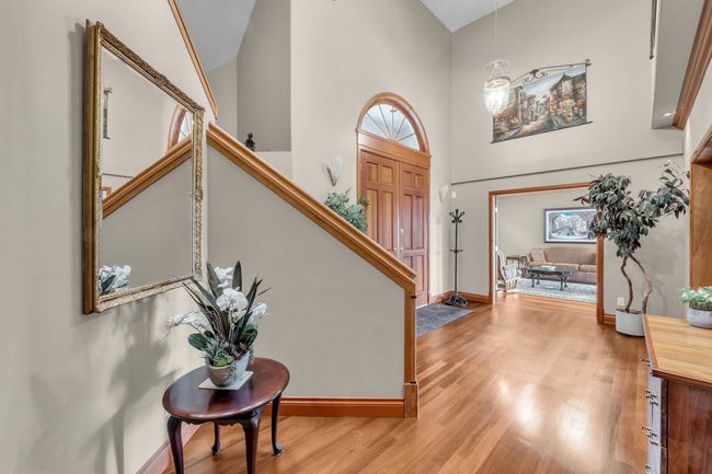 Foyer featuring baseboards, stairs, high vaulted ceiling, and wood finished floors | Image 24