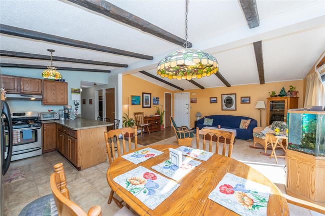 Dining space featuring vaulted ceiling with beams, a toaster, and a textured ceiling | Image 6