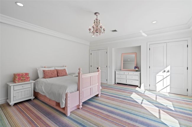 Unfurnished bedroom with dark colored carpet and an inviting chandelier | Image 21