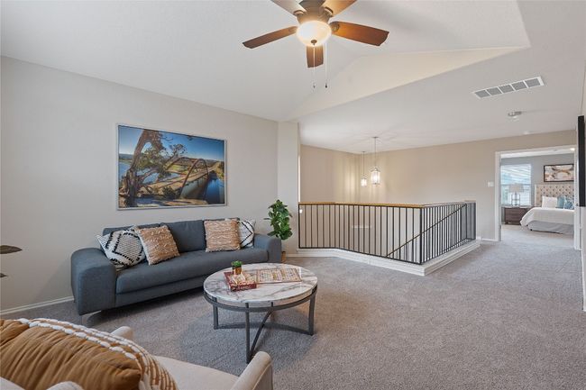 Living area with carpet flooring, lofted ceiling, and a ceiling fan | Image 22