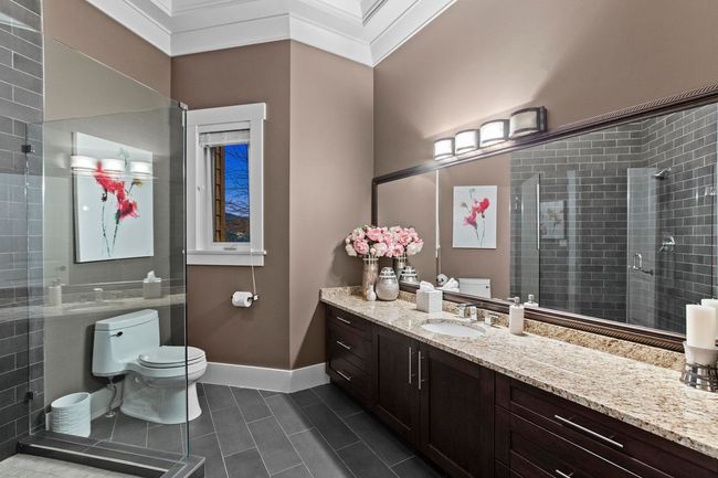 Bathroom with crown molding, toilet, vanity, a shower stall, and baseboards | Image 17