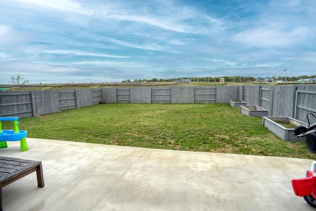 View of yard featuring a fenced backyard and a patio | Image 33