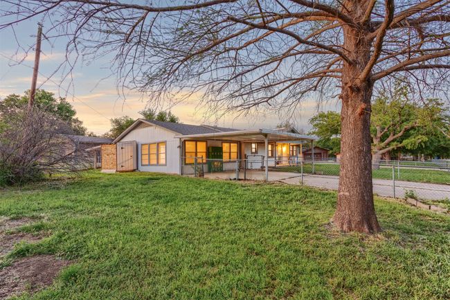 Rear view of property with a gate, a yard, fence private yard, and concrete driveway | Image 37