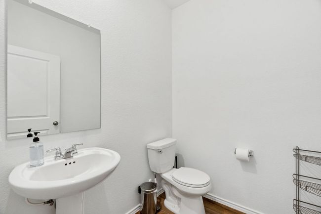 Bathroom with toilet, baseboards, a sink, and wood finished floors | Image 21