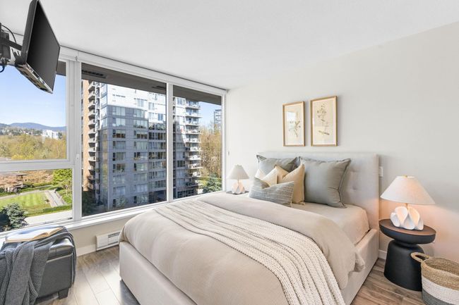Bedroom with baseboards, baseboard heating, wood finished floors, and multiple windows | Image 11