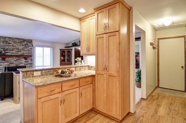 Off the kitchen is a hallway to garage and the laundry closet | Image 12