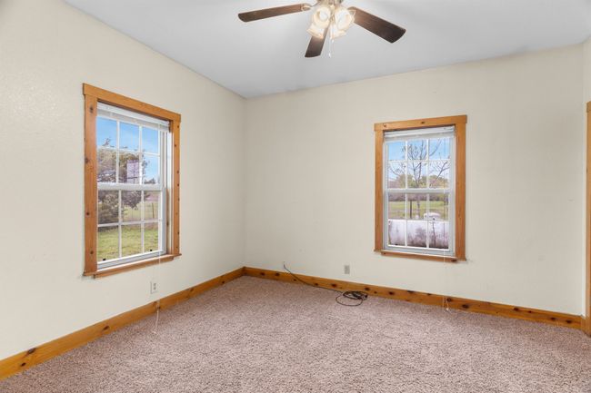 Unfurnished room with carpet floors, baseboards, a ceiling fan, and plenty of natural light | Image 29