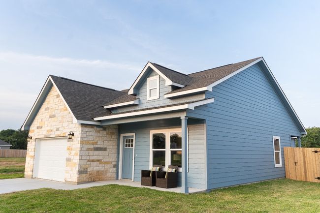 View of front of property with roof with shingles, an attached garage, stone siding, and driveway | Image 30