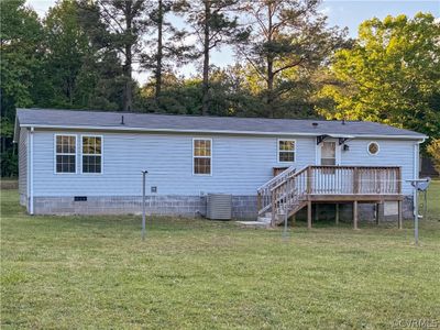 Back of house featuring a 10 x 12 salt treated deck, central AC, and a spacious backyard | Image 2