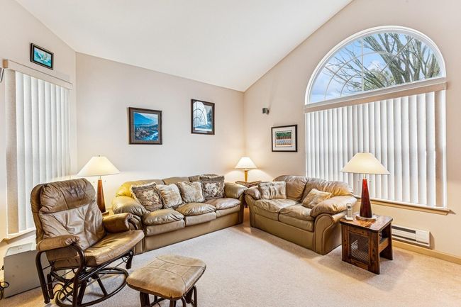 Living room featuring carpet flooring, high vaulted ceiling, and a baseboard heating unit | Image 24
