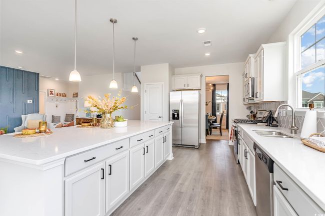 Kitchen featuring appliances with stainless steel finishes, plenty of natural light, white cabinets, and recessed lighting | Image 7