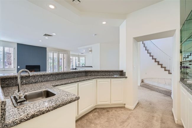 Kitchen with recessed lighting, light colored carpet, a fireplace, a sink, and visible vents | Image 33